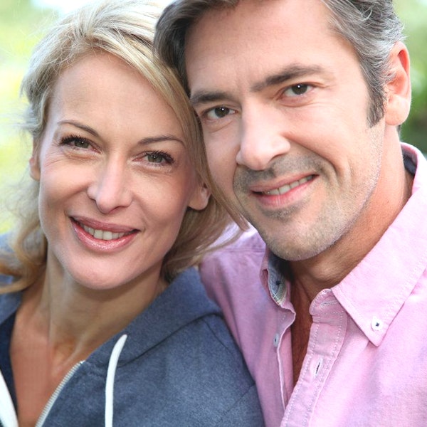Smiling couple showing restored confidence and healthy smiles thanks to dental implants in St. Louis by Dr. Schlaikjer, DDS.